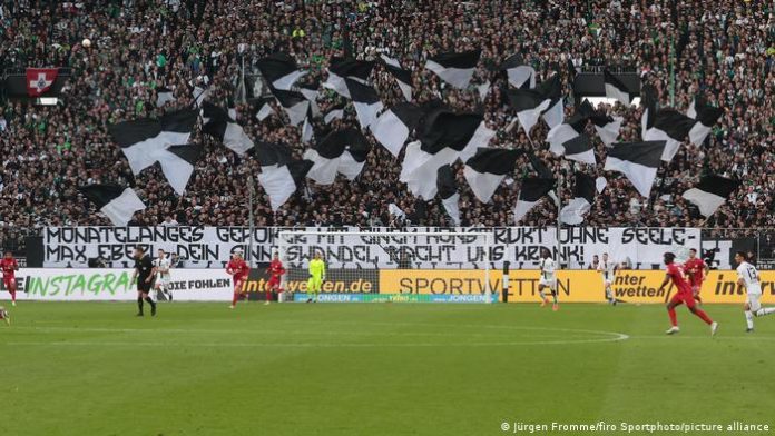 The picture shows a banner in the curve of the Mönchengladbach fans in the stadium.  It reads: Months of retching with a construct without a soul - Max Eberl, your change of heart is making us sick. 