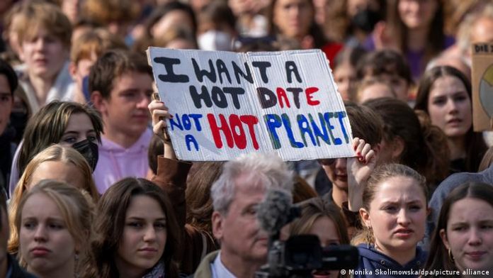 During the demonstration, a woman holds a sign that reads I want a hot date, not a hot planet