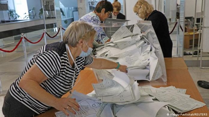 Women empty ballot boxes 