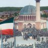 Painting of a mosque in the middle of the Wünsdorf-Zossen prison camp near Berlin.  A large number of people have gathered in front of the mosque.